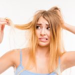Sad girl looking at her damaged hair. Copyright: deagreez / 123RF Stock Photo