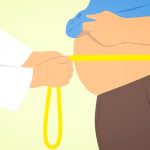 cartoon of a man's waist being measured by a doctor. Obesity is a symptom of metabolic syndrome.