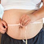 Waistline being measured. Allulose (psicose) could be a potential benefit in weight management.