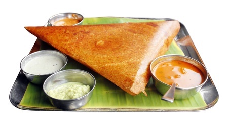 Dosa with various dressings on a pandanus leaf and all on a steel tray.