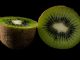 Kiwi fruit halves on a black background.