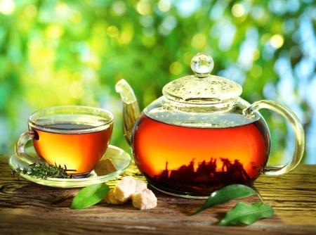 Cup of tea and teapot on a blurred background of nature