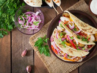 Mexican tacos with chicken, grilled vegetables and red onion. top view