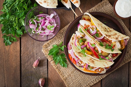Mexican tacos with chicken, grilled vegetables and red onion. top view