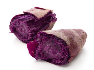 Purple ube, a yam cut in half on a white background.