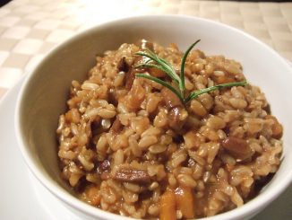 Brown rice risotto in a white bowl.