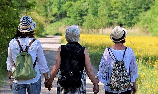 Three friends from the back walking down a lane. have all three experienced the menopause yet ?
