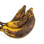Bunch of over ripe bananas on white background. Affected by tyrosinases and polyphenol oxidases.