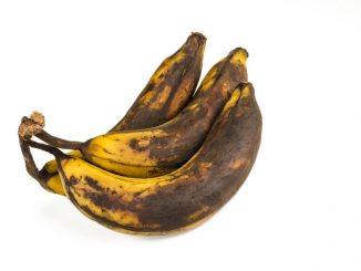 Bunch of over ripe bananas on white background. Affected by tyrosinases and polyphenol oxidases.