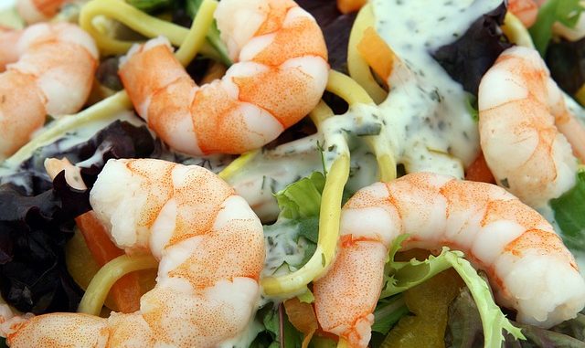 Cooked prawns on a salad bed with dressing.