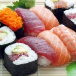 Different types of sushi, nigiri and sashimi on a rush plate