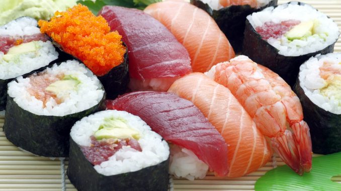 Different types of sushi, nigiri and sashimi on a rush plate