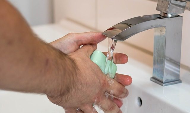 Washing hands with soap and water under a tap (faucet). A way to alleviate the spread of cold and flu virus.