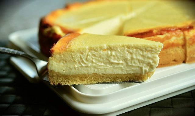 Cheesecake slice on a spoon, taken from a tart.
