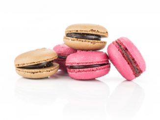 Pink and brown macaroons on a white background.