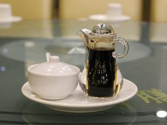 Soy sauce in a bottle with spout and a jar of soy paste.