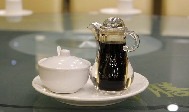 Soy sauce in a bottle with spout and a jar of soy paste.
