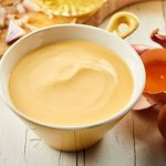 Hollandaise sauce. Bowl of gourmet creamy Hollandaise sauce made with egg yolks, butter, lemon juice and vinegar blended together in a close up view