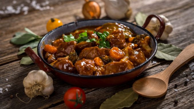 Boeuf bourguignon with vegetable on rustic wooden background