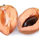 Mamey sapote (Pouteria sapota) fruit cut in half on white background