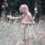 Girl collecting flowers in a meadow.