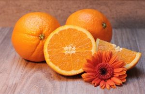 Oranges with an orange gerbera on a table as a source of vitamin C.