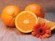 Oranges with an orange gerbera on a table as a source of vitamin C.. One of the top foods for tackling diabetes.