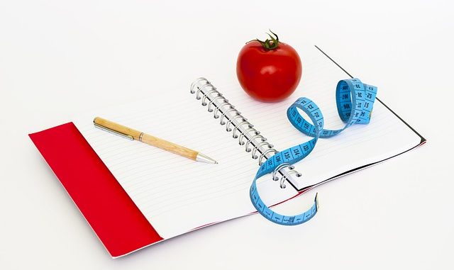 Notebook, apple, measuring tape and pencil. Images used to support various diets including Atkins Diet, the Slimfast diet