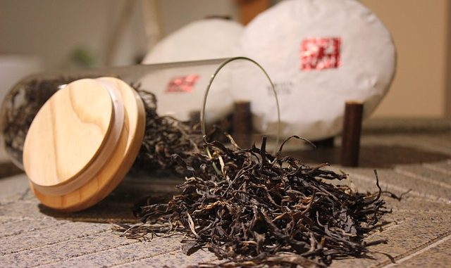 Black tea spilling from a jar onto a table.