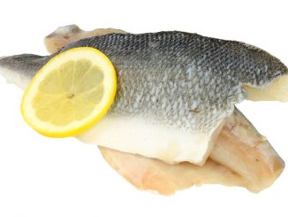 basa fillets with a slice of lemon on a white background