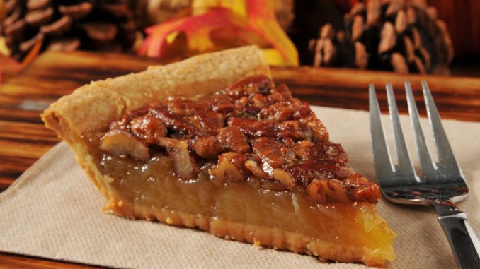 A slice of pecan pie with a festive autumn, thanksgiving background