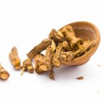 Raw dried Indian sarsaparilla in a clay bowl isolated on white used in many or almost Indian Asian flavored beverages.