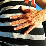 Person in black and white hooped top with hand over belly. An example of body shape.
