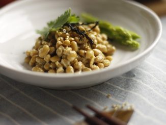 Natto in a white bowl with asparagus.
