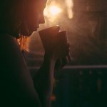 Tea drinker in silhouette aginst a bright early morning Sun.