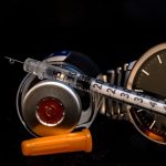 Insulin manufacture. The point of use shows a syringe resting on a stethoscope against a black background.