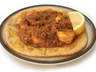 Prawn puri. Prawn puri, a tyical Indian dish, served with a slice of lemon, on a white background