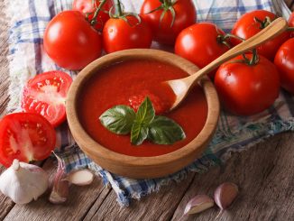 Homemade red tomato sauce with garlic and basil in a wooden bowl closeup. horizontal