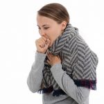 A girl having a cough on a white background. A case for treatment with bakumondoto.
