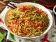 Vegetable Chow mein, noodles and vegetables dish with wooden chopsticks.