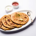Aloo Paratha / Indian Potato stuffed Flatbread. Served with fresh curd and tomato ketchup. selective focus