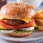 A beyond delicious plant based alternative meat cheeseburger with lettuce, onion, pickle, tomato and french fries.