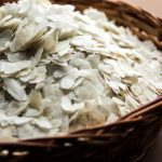 Raw Flattened Rice or Thick or thin Rice Flakes for Namkeen Chivda snacks or Aloo Poha for Indian Breakfast, served in a bowl
