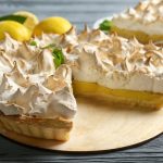 Yummy lemon meringue pie on wooden table.