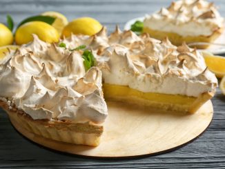 Yummy lemon meringue pie on wooden table.