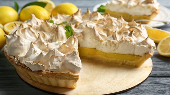 Yummy lemon meringue pie on wooden table.
