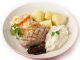 Veal sirloin steak with onion marmalade, celeriac puree, julienned carrots in a white sauce and boiled potatoes, garnished with parsley.