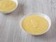 Homemade vanilla custard in bowls over white wooden background , low angle view. Close-up.
