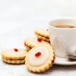 Empire biscuits on a white background with a cup of tea or coffee.