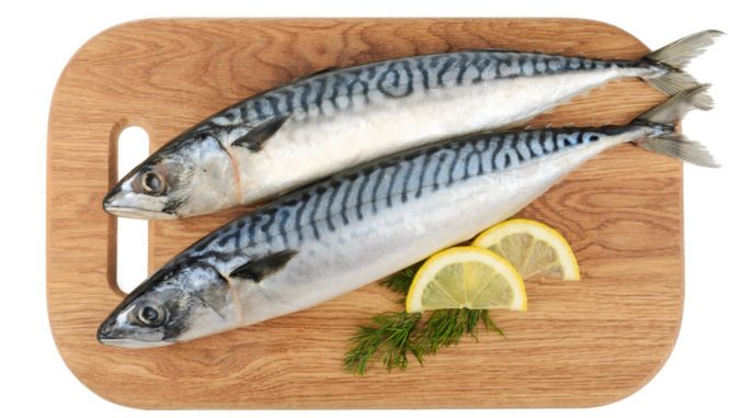 mackerel fish on wooden plate isolated.. Ready to be turned into butterflied mackerel.